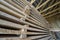 Neatly piled long stack of wooden boards inside attic room under construction