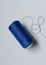 neatly rolled blue sewing thread
