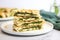 neatly stacked chicken pesto paninis on white plate