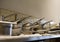 Neatly stacked stainless steel pans and pots standing on shelf in restaurant kitchen ready to use