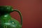 The neck of a green amphora close-up on a red background