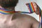 Neck of a young bearded man is entwined with a rainbow LGBT tape and strangles him