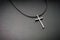 Necklace with metallic cross on dark background