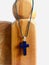 A necklace with a pendant of the holy cross hanging on a wooden stand. Vertical photo image.