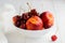 Nectarines, cherries with water droplets in white bowl
