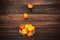 Nectarines in transparent glass bowl on wooden plank background, two fruits in the air above the rest