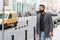 Need a taxi. Businessman catching taxi while standing outdoors urban background. Man bearded hipster casual style