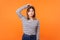 Need to think. Portrait of confused young woman with brown hair in long sleeve striped shirt. isolated on orange background