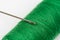 Needle head on the green thread over white background