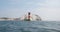 The Needles Lighthouse, Isle of Wight, with chalk cliffs and waves on the blue sea