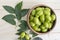 Neem green leaf and neem fruit on wooden table. Neem oil is moisturizing oil and contains various compounds that have insecticidal