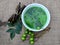 Neem leaves, fruits, and branches on jute fabric background. Neem medicinal herb juice in bowl. Neem liquid ayurveda medicine