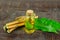 Neem oil in bottle and neem leaf on wooden background.