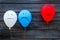 Negative emotions concept. Balloons with drawn faces on dark wooden background top view