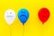 Negative emotions concept. Balloons with drawn faces on yellow background top view