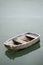 Neglected old rowing boat on calm sea water