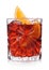 Negroni Cocktail in crystal glass with ice cubes and orange slice on white background with reflection