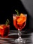 Negroni cocktail with smoking rosemary and orange garnish on black background