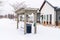 Neighborhood on a winter setting with bench pergola and buildings against snow