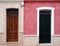 Neighboring different colored front doors next to each other in residential old houses painted in pink and white