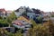 Neighbourhood with densely built old dilapidated apartment building and large family houses surrounded with trees