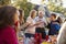 Neighbours talk and eat at a block party, close up