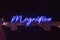 Neon blue lights with the word Magnifico written out in script type.