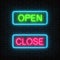 Neon green open and red close glowing signs in geometric shape on a brick wall background.