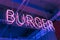 neon illuminated letters burger in the window of a fast food restaurant