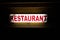 Neon light on a wall showing Restaurant text