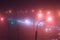 Neon lights of night city and motion traffic in fog