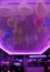 Neon lit purple ceiling with many party balloons