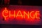 Neon orange change sign in a dark room