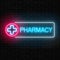 Neon pharmacy glowing signboard on brick wall background. Illuminated drugstore sign open 24 hours.