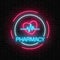 Neon pharmacy glowing signboard with heart shape and pulse graph in circle frames on brick wall background.