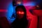 Neon portrait of young depressed asian woman with streak of red light on face taking bath in clothes