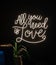 Neon sign inscription all you need is love on a dark background