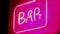 Neon sign saying BAR nightlife angled close shot