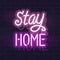 Neon stay home handwritten lettering. Glowing vector motivation typography. Fluorescent letters on dark brick wall