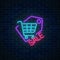 Neon supermarket sale sign with shopping cart in tag on a dark brick wall background. Luminous advertising signboard.