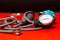 Neonatal stethoscope and Pediatrics sphygmomanometer on red with black background, children and newborn blood pressure control,
