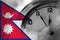 Nepal, Nepali, Nepalese flag with clock close to midnight in the background. Happy New Year concept