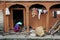 Nepalese woman scribbles a wand on the doorstep of the house, for making baskets for vegetables.