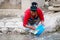 Nepalese woman is washing potatoes, before preparing food in the stream, which flows along the street.