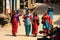 Nepalese women in saris and traditional bright colorful clothes walk along the street of Tansen city