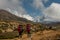 Nepali porters carrying large loads of bags on his back along a