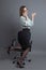 Nerd businesswoman kneeling on chair and calling