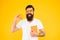 Nerd is the new cool. Bearded nerd man. Study nerd holding book and orange fruit on yellow background. Book nerd in