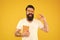 Nerd is the new cool. Bearded nerd man. Study nerd holding book and orange fruit on yellow background. Book nerd in