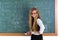 Nerd pupil blond girl in green board schoolgirl